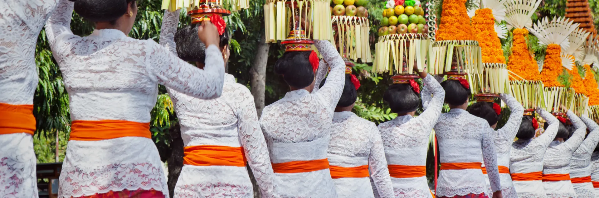 Balinese women walking with food and fruit offerings for Banten Tegeh/Gebogan to be presented during a village temple celebration