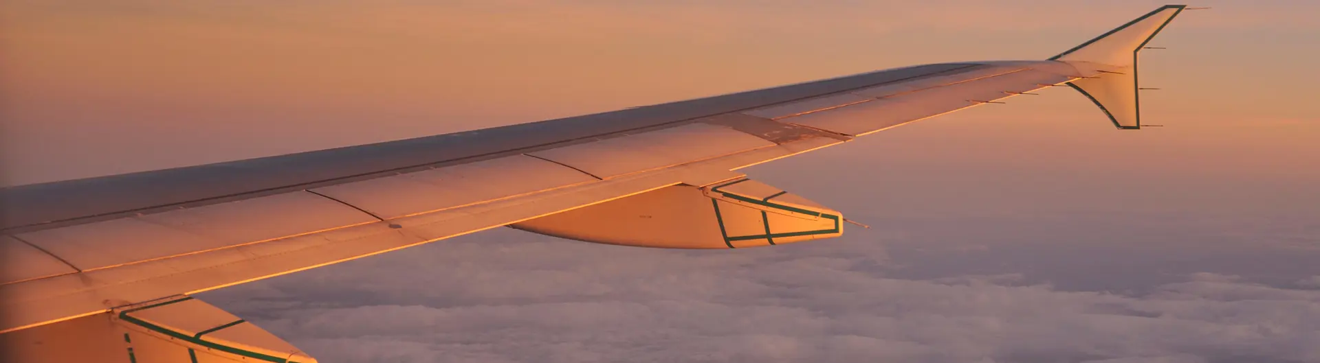 Aircraft wing in sky above clouds